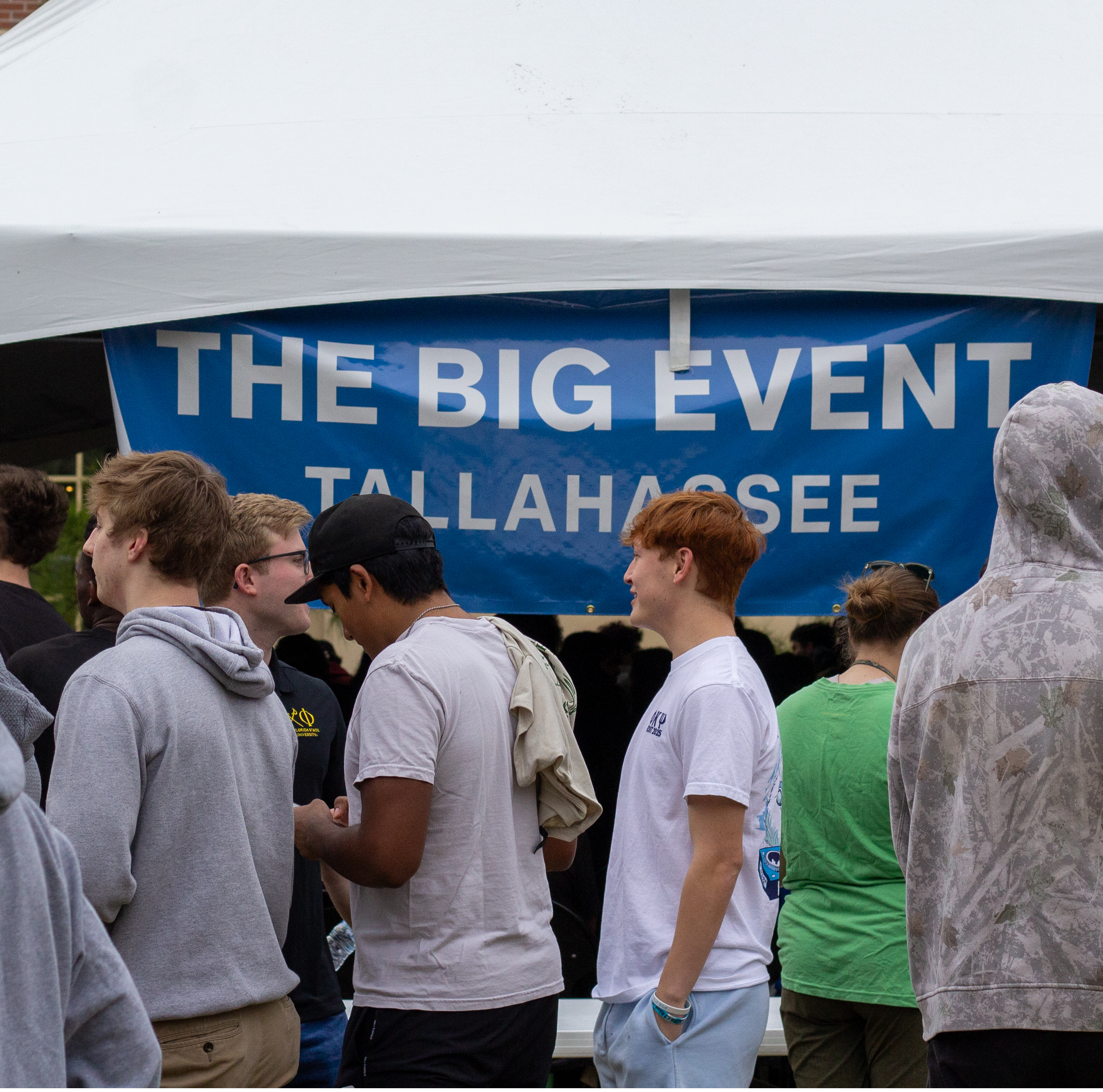 students lining up in front of a big event tent